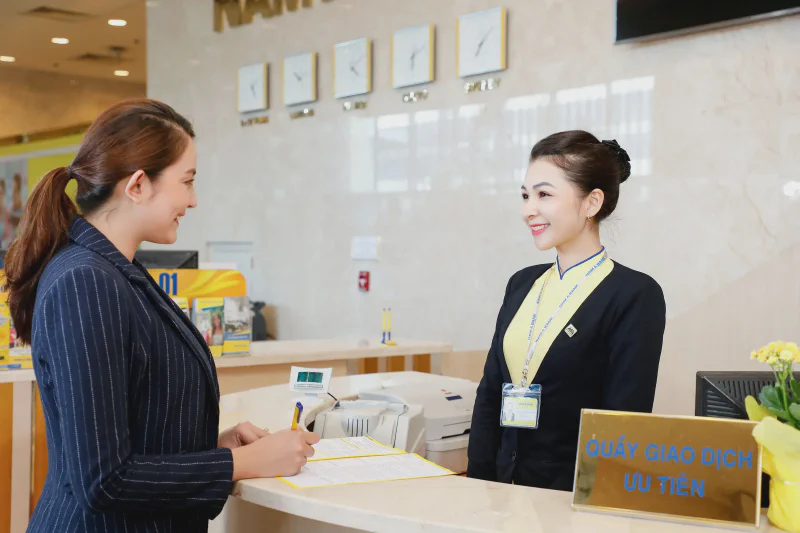 Bank teller serving a customer at a Vietnamese bank branch